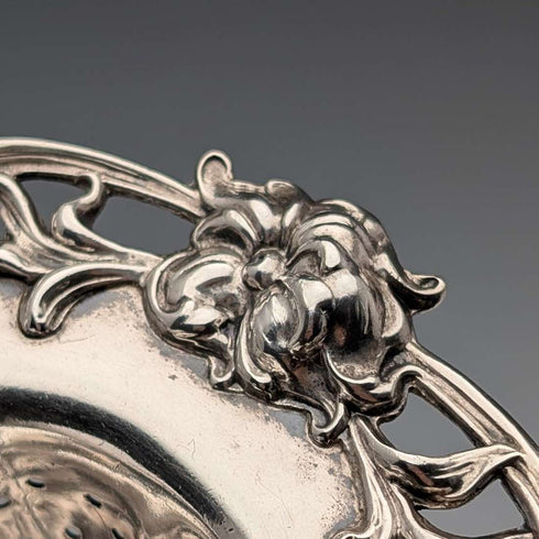Antique American sterling silver tea strainer with floral decoration