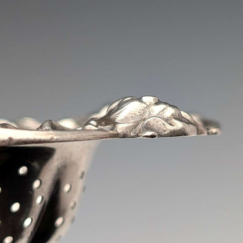 Antique American sterling silver tea strainer with floral decoration